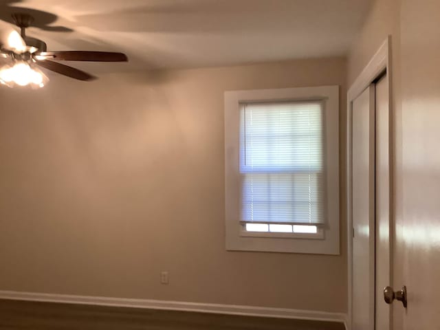 unfurnished room with ceiling fan and dark hardwood / wood-style flooring