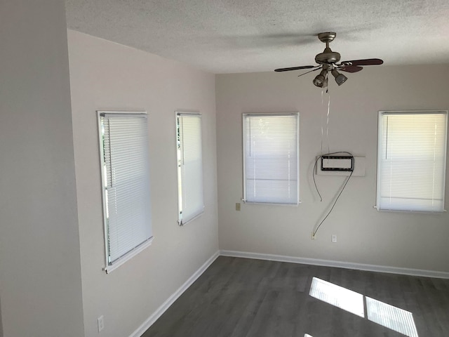 empty room with dark wood-type flooring, ceiling fan, and a textured ceiling