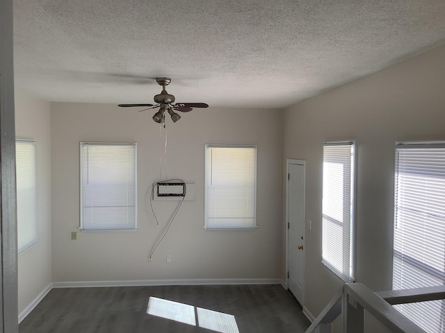 unfurnished room with dark wood-type flooring, ceiling fan, and a textured ceiling