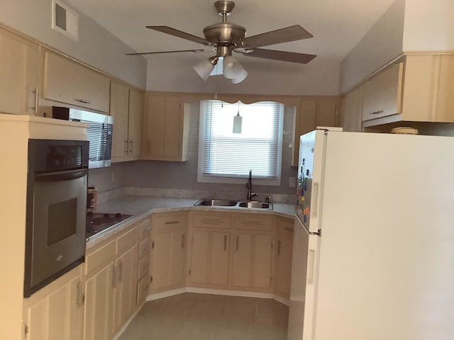 kitchen featuring cream cabinetry, stainless steel appliances, sink, light tile patterned flooring, and ceiling fan