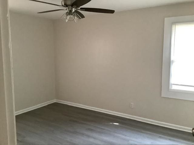 unfurnished room featuring dark wood-type flooring and ceiling fan