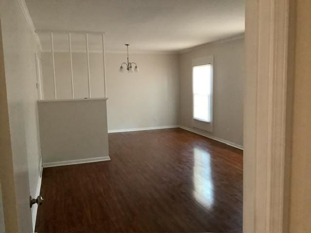 unfurnished room with ornamental molding, a chandelier, and dark hardwood / wood-style flooring