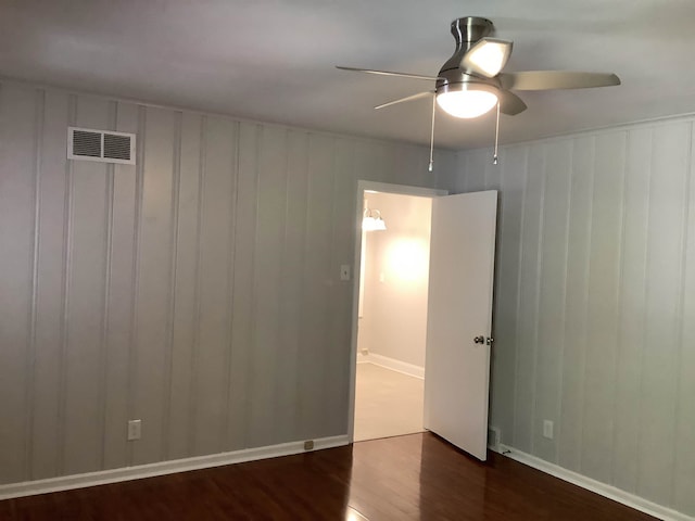 unfurnished room featuring ceiling fan and dark hardwood / wood-style floors