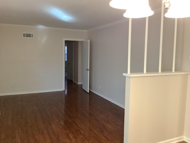 unfurnished room featuring dark wood-type flooring and crown molding