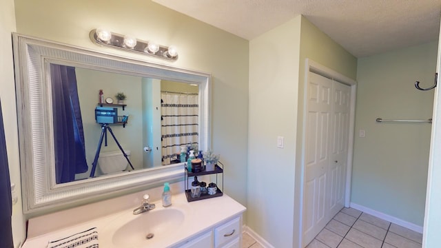 bathroom with vanity, a textured ceiling, and tile patterned flooring