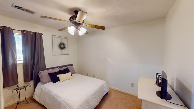 carpeted bedroom featuring a textured ceiling and ceiling fan