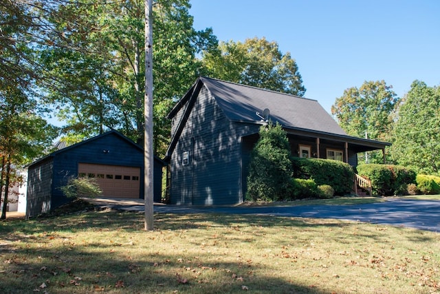 view of home's exterior featuring a yard, an outdoor structure, and a garage