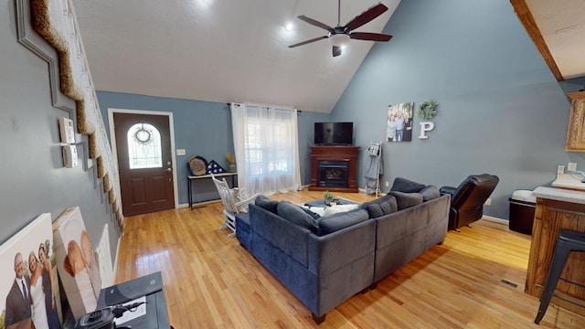 living room featuring high vaulted ceiling, light hardwood / wood-style floors, and ceiling fan