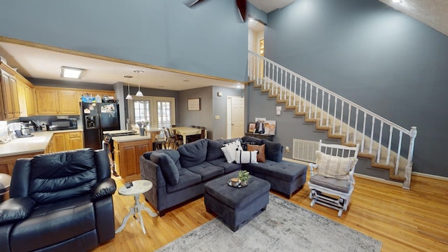 living room with light hardwood / wood-style flooring and a high ceiling