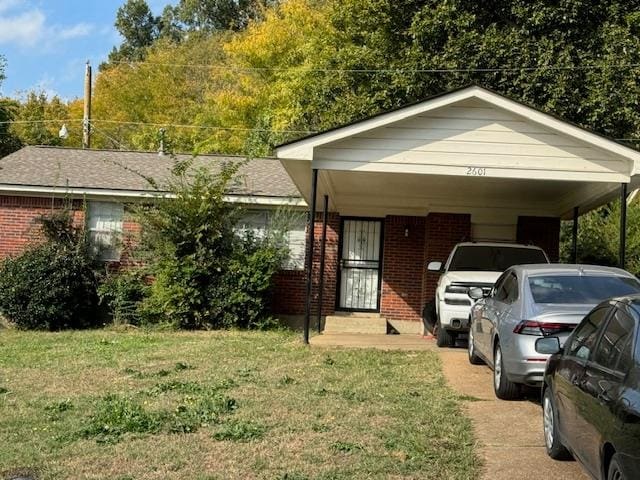 view of front of house with a front yard and a carport