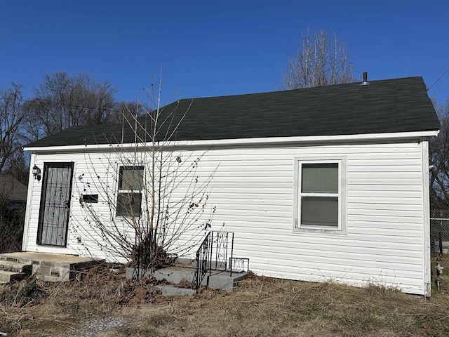 exterior space featuring roof with shingles