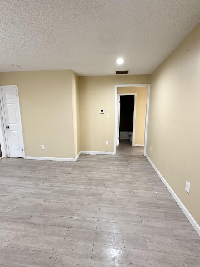 unfurnished room with a textured ceiling