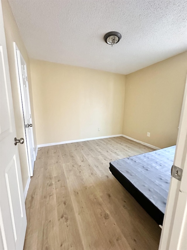 unfurnished bedroom featuring light hardwood / wood-style floors and a textured ceiling