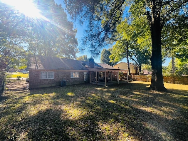 back of house featuring cooling unit and a yard