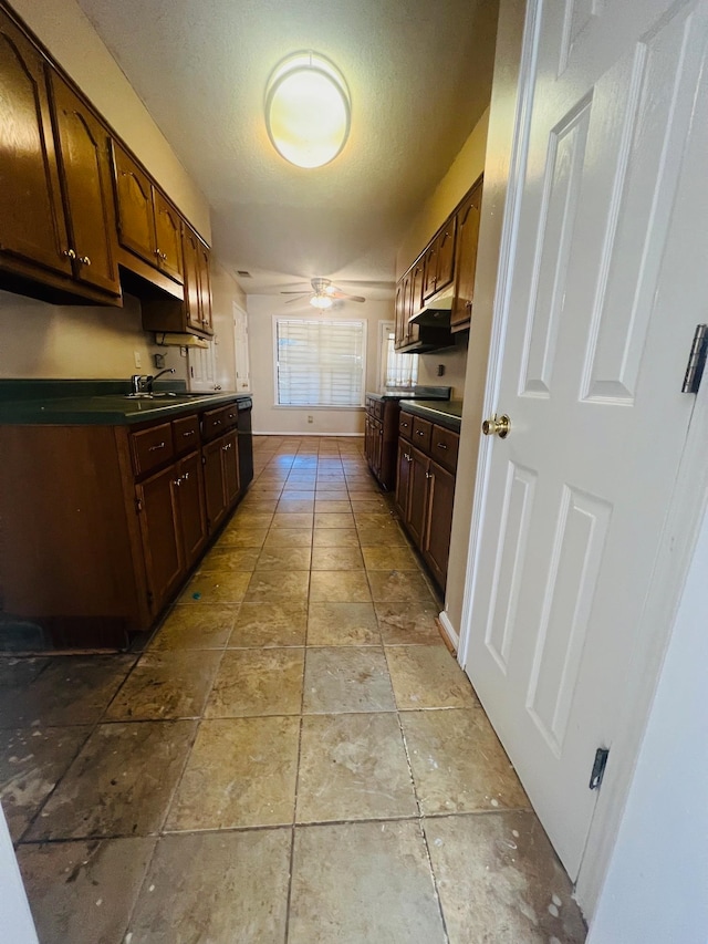 kitchen featuring a textured ceiling, dark brown cabinetry, sink, and ceiling fan