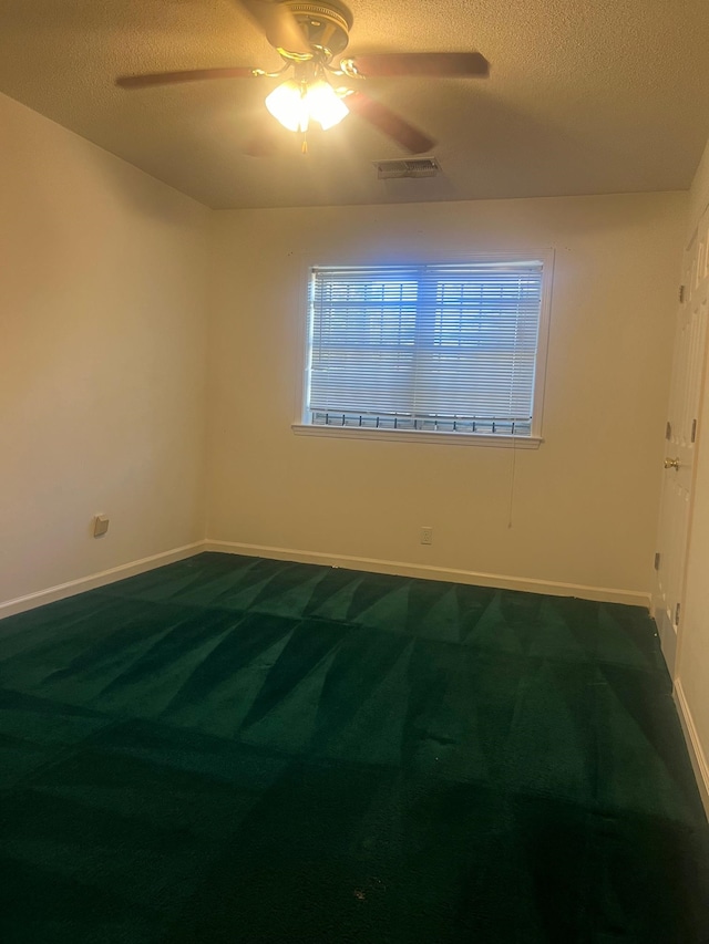 carpeted empty room with a textured ceiling and ceiling fan