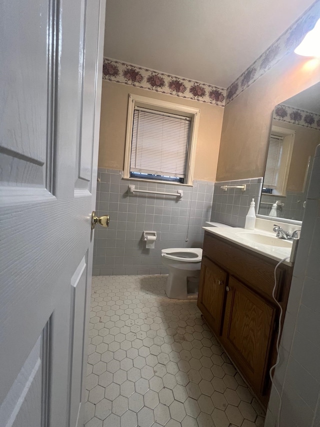 bathroom featuring vanity, toilet, tile walls, and tile patterned flooring