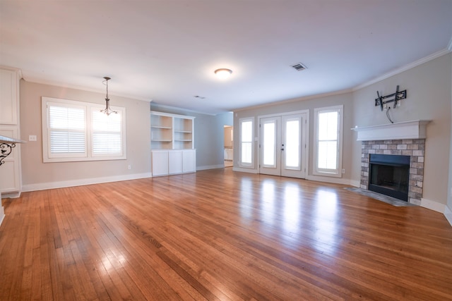 4543 Charleswood Ave, Memphis, TN 38117 - unfurnished living room with built in features, a brick fireplace, hardwood / wood-style floors, ornamental molding, and an inviting chandelier