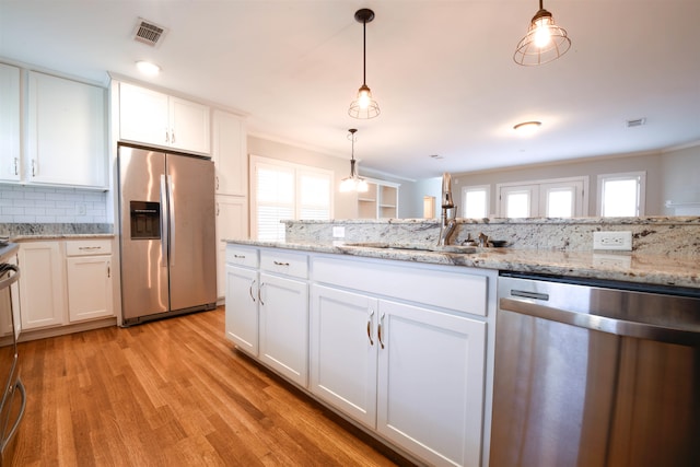 4543 Charleswood Ave, Memphis, TN 38117 - kitchen featuring sink, stainless steel appliances, decorative light fixtures, white cabinets, and light hardwood / wood-style flooring