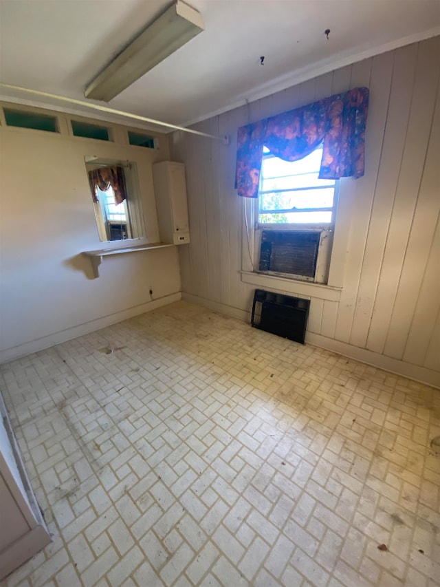 unfurnished living room featuring wooden walls