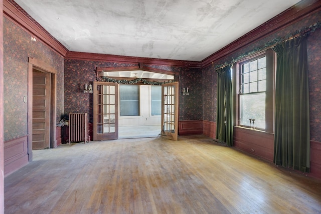1625 Peabody Ave, Memphis, TN 38104 - unfurnished room featuring wood finished floors, crown molding, wallpapered walls, a wainscoted wall, and radiator heating unit