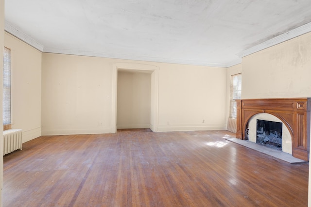 unfurnished living room with crown molding, light hardwood / wood-style flooring, and radiator heating unit