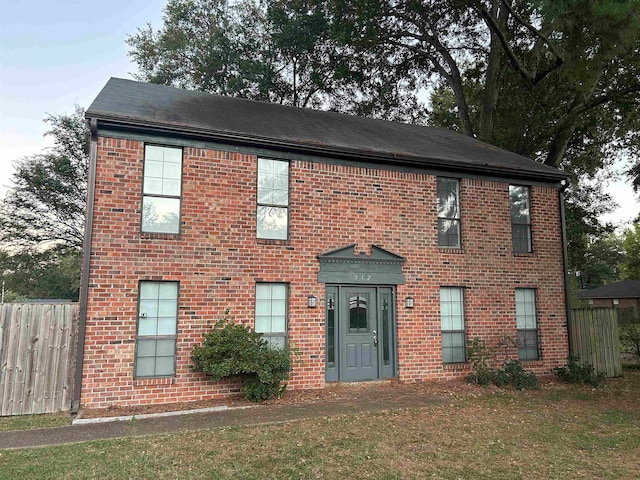 colonial-style house featuring a front yard