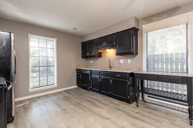 kitchen featuring plenty of natural light, stainless steel fridge, dishwasher, and light wood-type flooring