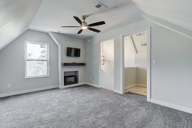 unfurnished living room with ceiling fan, carpet flooring, and vaulted ceiling