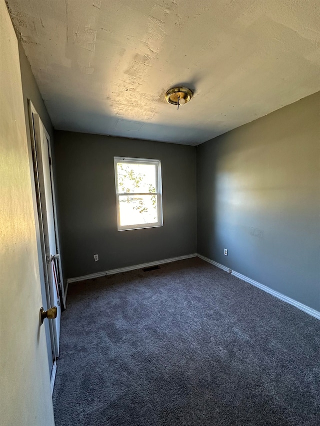 empty room featuring dark carpet