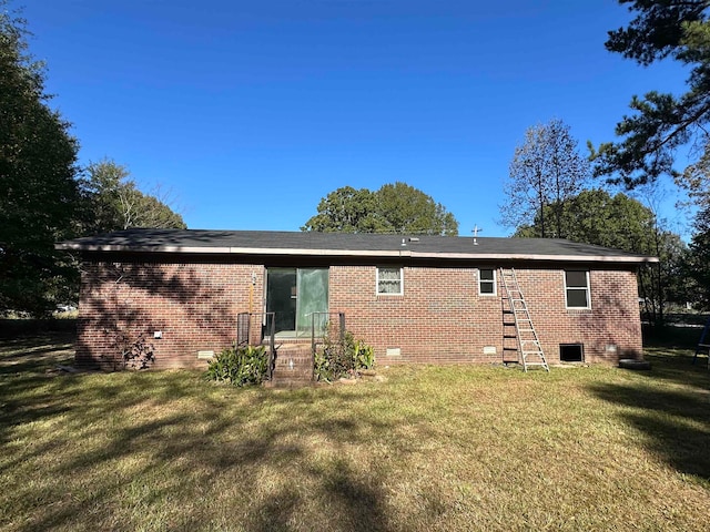 rear view of property with a lawn