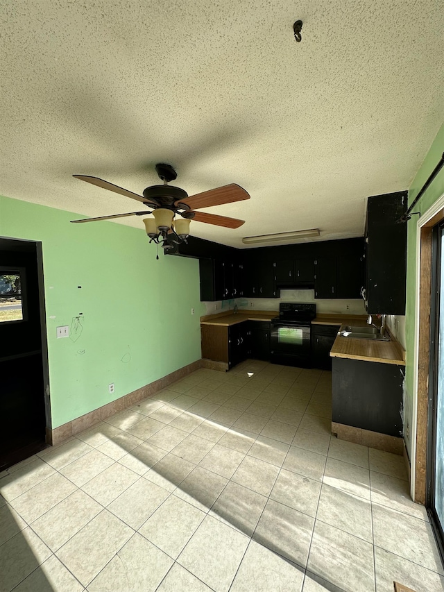 kitchen featuring sink, a textured ceiling, ceiling fan, black / electric stove, and light tile patterned floors