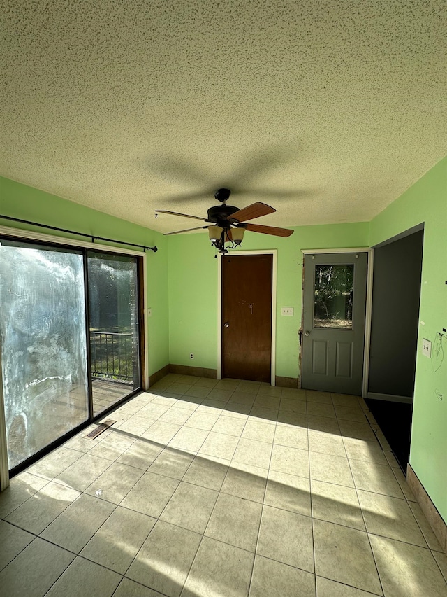 tiled spare room featuring a textured ceiling and ceiling fan