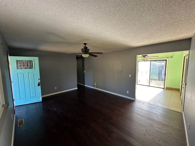 interior space featuring ceiling fan, wood-type flooring, and a textured ceiling