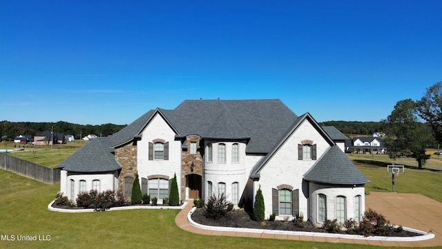 french provincial home featuring a front yard