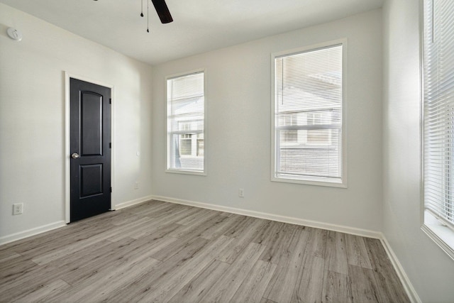 unfurnished room featuring ceiling fan, light wood-type flooring, and a wealth of natural light