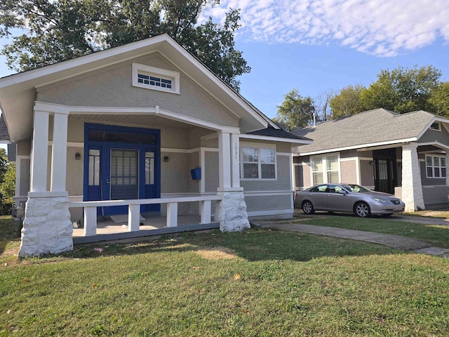 view of front of house featuring covered porch and a front lawn