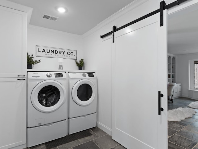 laundry room with crown molding, washer and clothes dryer, and a barn door