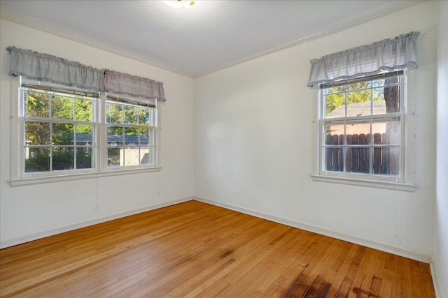 unfurnished room featuring ornamental molding, plenty of natural light, and hardwood / wood-style floors