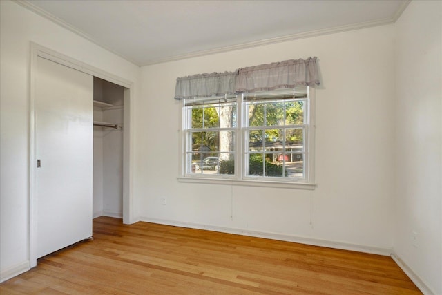 unfurnished bedroom featuring light hardwood / wood-style flooring, ornamental molding, and a closet