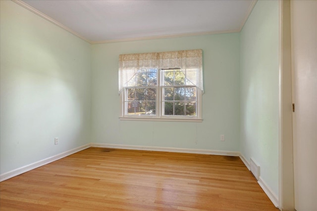 empty room featuring ornamental molding and light hardwood / wood-style flooring