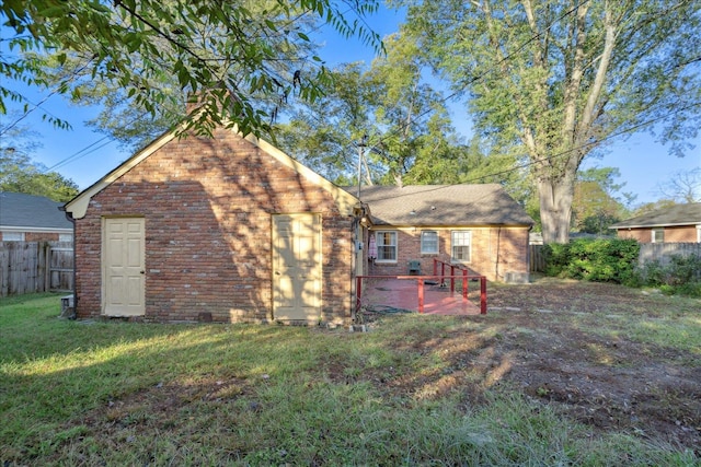 rear view of property featuring a lawn