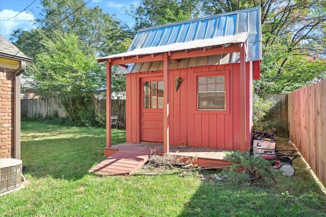 view of outbuilding featuring a yard and central air condition unit