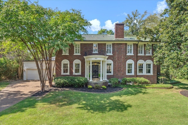 view of front of home with an outdoor structure, a front lawn, and a garage