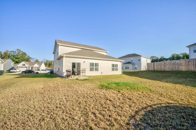 rear view of property featuring a patio and a lawn