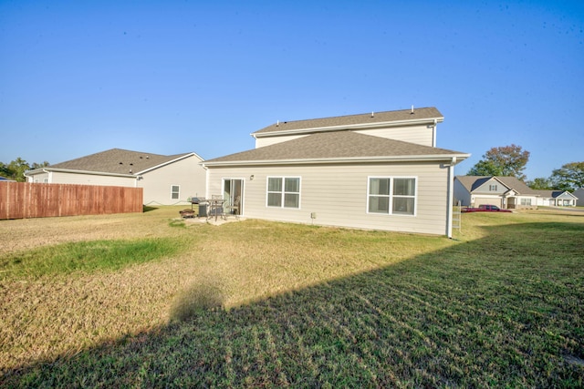 rear view of house with a patio and a lawn