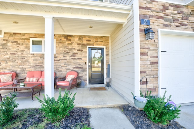 view of exterior entry featuring an outdoor living space and a garage