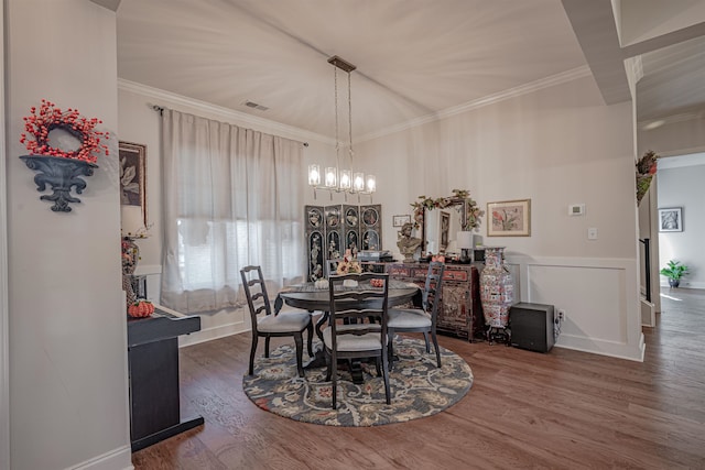 dining space featuring an inviting chandelier, crown molding, and dark hardwood / wood-style flooring