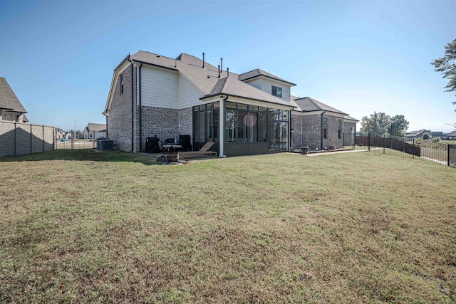 rear view of property featuring central AC, a lawn, and a sunroom