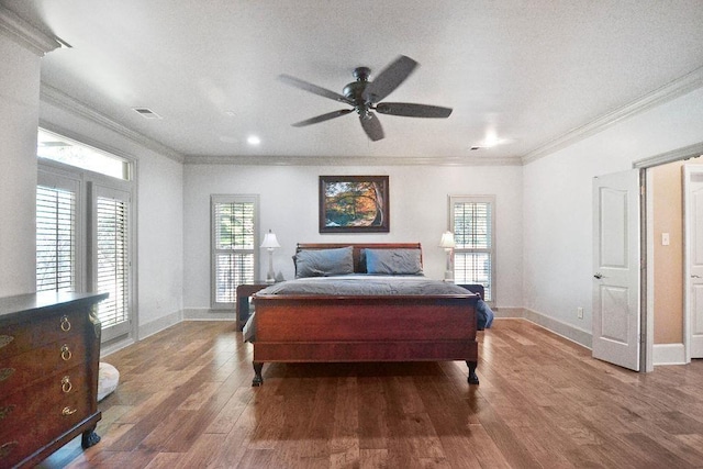 bedroom featuring wood finished floors, ornamental molding, and baseboards